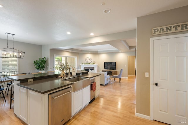 1238 Darling St, Napa, CA 94558 - kitchen featuring stainless steel dishwasher, dark countertops, white cabinetry, a kitchen island with sink, and healthy amount of natural light