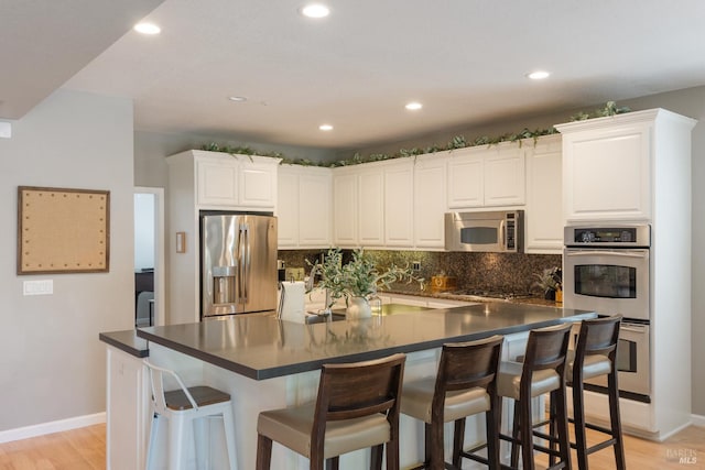 1238 Darling St, Napa, CA 94558 - kitchen featuring appliances with stainless steel finishes, light wood-style flooring, dark countertops, recessed lighting, and decorative backsplash
