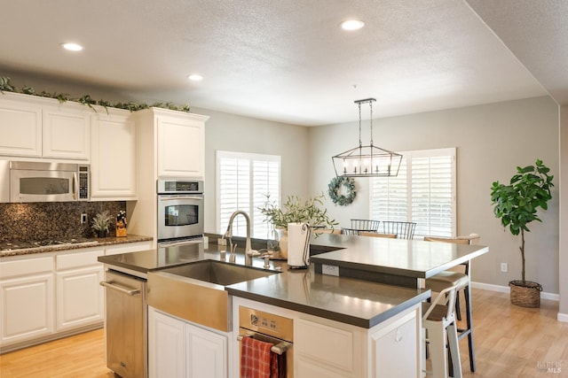 1238 Darling St, Napa, CA 94558 - kitchen featuring appliances with stainless steel finishes, dark countertops, light wood-style flooring, recessed lighting, and a textured ceiling