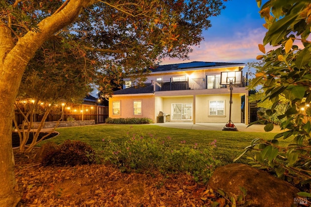 1238 Darling St, Napa, CA 94558 - rear view of property featuring a balcony, a patio area, roof mounted solar panels, stucco siding, and a lawn