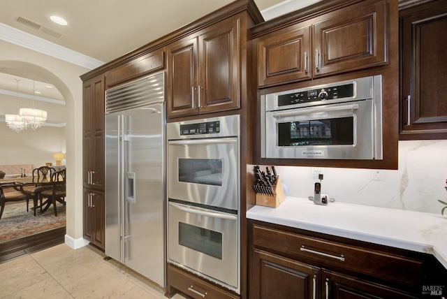 2986 Pebble Beach Cir, Fairfield, CA 94534 - kitchen featuring appliances with stainless steel finishes, a chandelier, ornamental molding, light countertops, and dark brown cabinetry