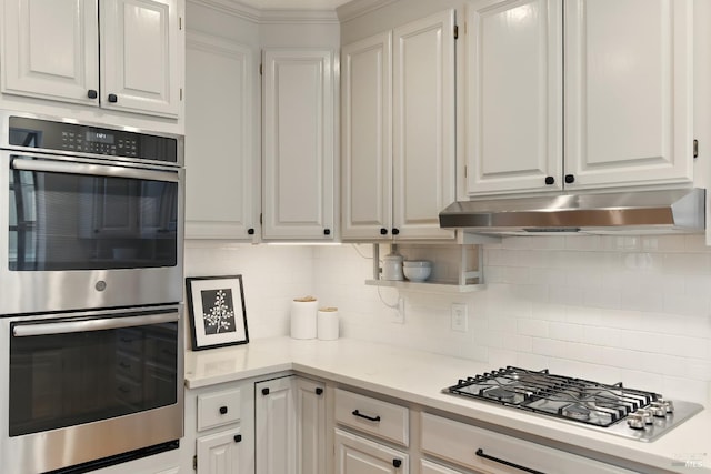 1572 Vista St, Oakland, CA 94602 - kitchen featuring appliances with stainless steel finishes, under cabinet range hood, white cabinets, tasteful backsplash, and crown molding