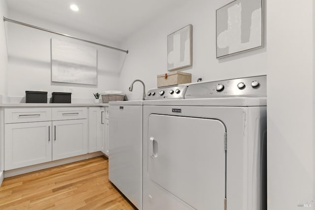 1572 Vista St, Oakland, CA 94602 - washroom with washing machine and clothes dryer, light wood-style floors, and cabinet space