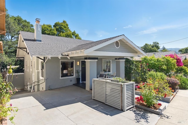 1572 Vista St, Oakland, CA 94602 - view of front of property featuring a shingled roof, a chimney, stucco siding, and a patio