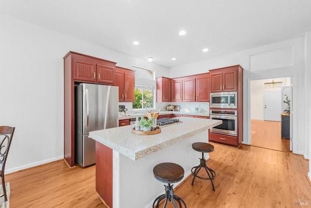 2832 Parkview Ter, Fairfield, CA 94534 - kitchen with stainless steel appliances, light wood-style floors, a kitchen bar, a kitchen island, and recessed lighting