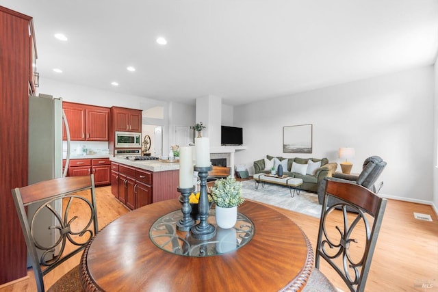 2832 Parkview Ter, Fairfield, CA 94534 - dining area featuring light wood-style floors, a fireplace, recessed lighting, and baseboards