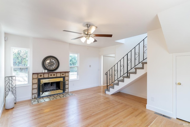 7 Fairview Ave, Vallejo, CA 94590 - unfurnished living room with ceiling fan, stairs, wood finished floors, a tiled fireplace, and baseboards