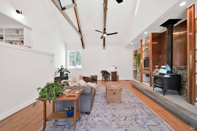 9 Spring Meadows Rd, Mccloud, CA 96507 - living room featuring a wood stove, ceiling fan, wood finished floors, wood ceiling with exposed beams, and baseboards