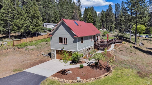 9 Spring Meadows Rd, Mccloud, CA 96507 - view of front of home featuring stone siding, driveway, a wooden deck, an attached garage, and stairway