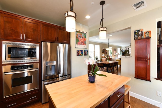 1617 Pear Tree Ln, Napa, CA 94558 - kitchen featuring appliances with stainless steel finishes, butcher block countertops, baseboards, dark wood-type flooring, and decorative light fixtures