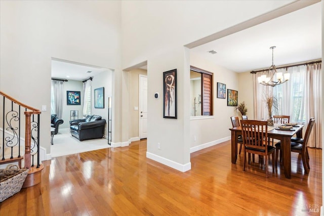 428 Lloyd Ct, Benicia, CA 94510 - dining room featuring stairway, a chandelier, light wood-style flooring, and baseboards