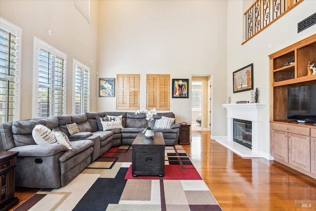 428 Lloyd Ct, Benicia, CA 94510 - living area with a high ceiling, wood finished floors, a glass covered fireplace, and baseboards
