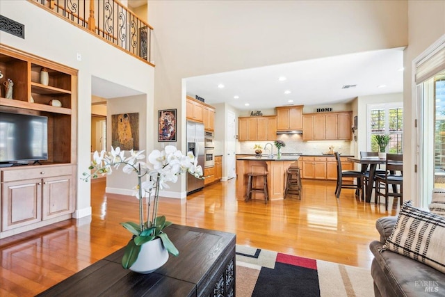 428 Lloyd Ct, Benicia, CA 94510 - living room with light wood-type flooring, baseboards, a high ceiling, and recessed lighting
