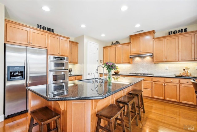 428 Lloyd Ct, Benicia, CA 94510 - kitchen with appliances with stainless steel finishes, a sink, light wood-type flooring, a breakfast bar, and recessed lighting