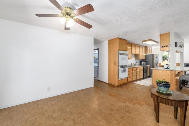 103 Quail Ct, Winters, CA 95694 - kitchen with white double oven, freestanding refrigerator, black dishwasher, a kitchen breakfast bar, and light countertops