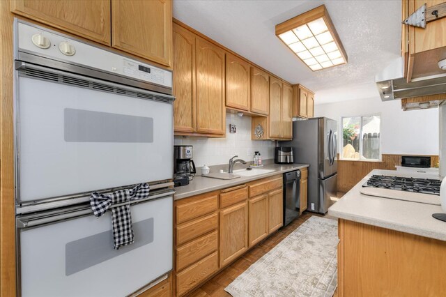 103 Quail Ct, Winters, CA 95694 - kitchen featuring black appliances, a sink, light countertops, backsplash, and wood finished floors
