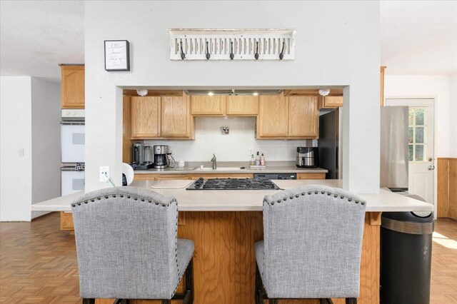103 Quail Ct, Winters, CA 95694 - kitchen with stainless steel appliances, a sink, decorative backsplash, and a kitchen breakfast bar