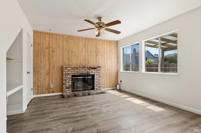 404 Mellowood Ct, Suisun City, CA 94585 - unfurnished living room with ceiling fan, wooden walls, wood finished floors, and a brick fireplace