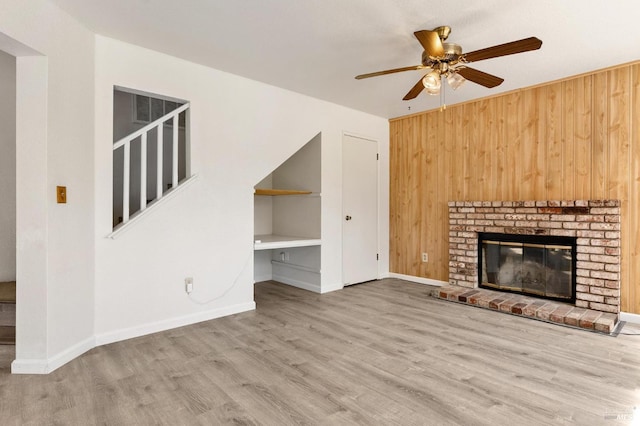 404 Mellowood Ct, Suisun City, CA 94585 - unfurnished living room with wooden walls, ceiling fan, wood finished floors, and a fireplace
