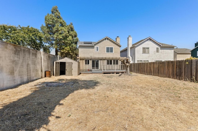 404 Mellowood Ct, Suisun City, CA 94585 - rear view of house with a storage shed, a fenced backyard, a wooden deck, and solar panels