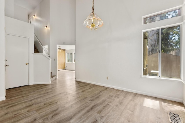 404 Mellowood Ct, Suisun City, CA 94585 - empty room with stairway, a towering ceiling, wood finished floors, and a chandelier