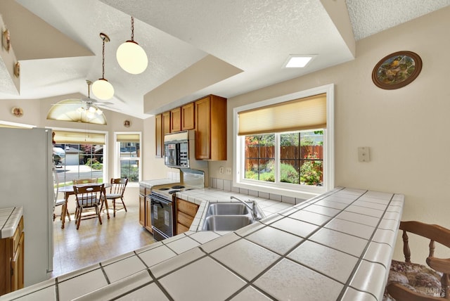 2340 Canton Ct, Fairfield, CA 94534 - kitchen featuring tile countertops, white appliances, brown cabinetry, a textured ceiling, and vaulted ceiling