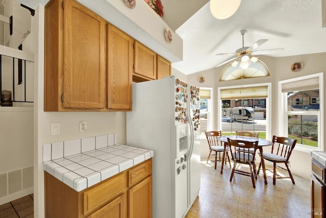 2340 Canton Ct, Fairfield, CA 94534 - kitchen with white refrigerator with ice dispenser, plenty of natural light, tile countertops, ceiling fan, and lofted ceiling