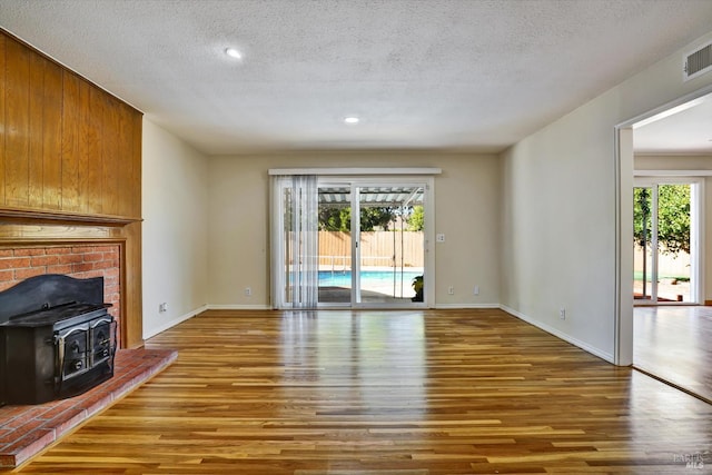 8567 Davona Dr, Dublin, CA 94568 - unfurnished living room with a wood stove, wood finished floors, a textured ceiling, and recessed lighting