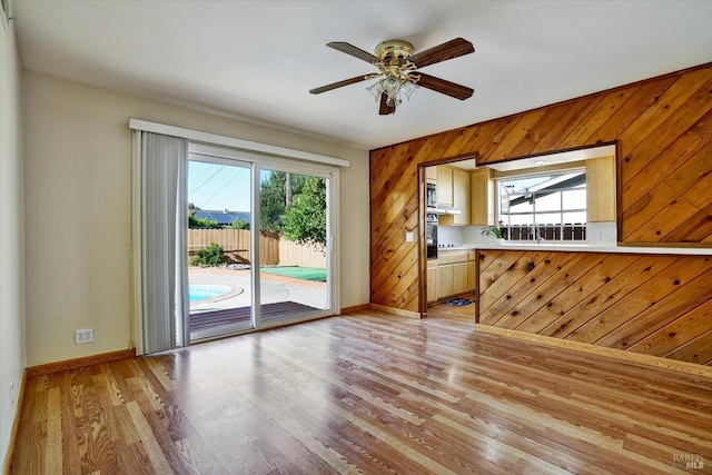 8567 Davona Dr, Dublin, CA 94568 - unfurnished living room featuring plenty of natural light, light wood-type flooring, a ceiling fan, and wooden walls