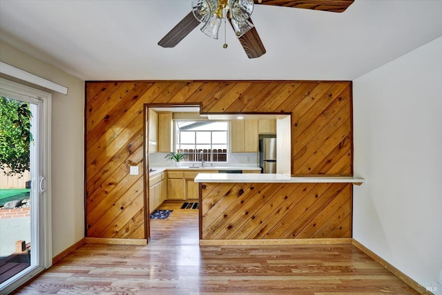 8567 Davona Dr, Dublin, CA 94568 - kitchen with light countertops, light brown cabinets, a ceiling fan, a peninsula, and light wood-type flooring