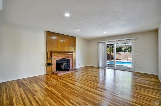 8567 Davona Dr, Dublin, CA 94568 - unfurnished living room with a wood stove, wood finished floors, a textured ceiling, and recessed lighting