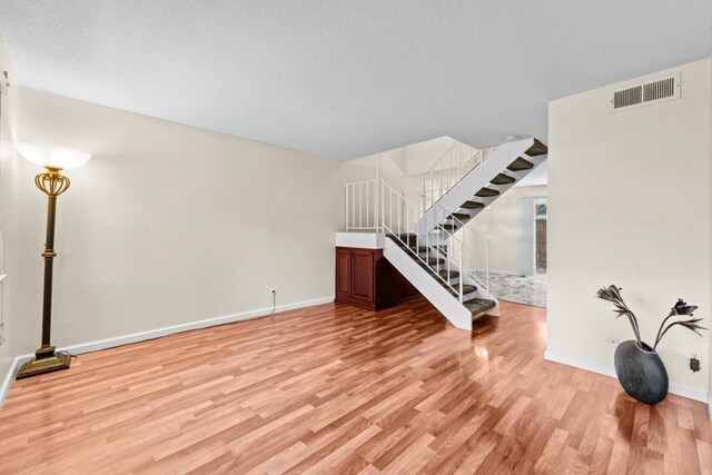 4014 Knoll Top Ct, Carmichael, CA 95608 - unfurnished living room with light wood-style floors, stairs, and a textured ceiling