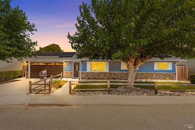 216 Walnut St, Suisun City, CA 94585 - view of front facade with stucco siding, stone siding, a fenced front yard, concrete driveway, and a garage