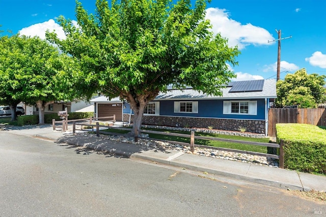 216 Walnut St, Suisun City, CA 94585 - view of front facade with stone siding, roof mounted solar panels, an attached garage, stucco siding, and a shingled roof