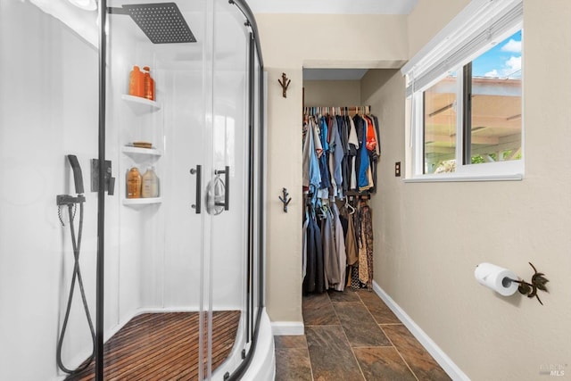 216 Walnut St, Suisun City, CA 94585 - bathroom featuring stone tile floors, a stall shower, healthy amount of natural light, and a walk in closet