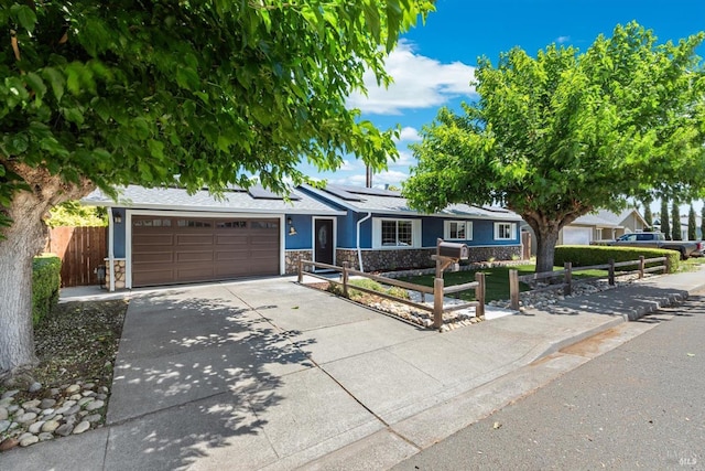 216 Walnut St, Suisun City, CA 94585 - ranch-style house featuring stone siding, an attached garage, driveway, and roof mounted solar panels