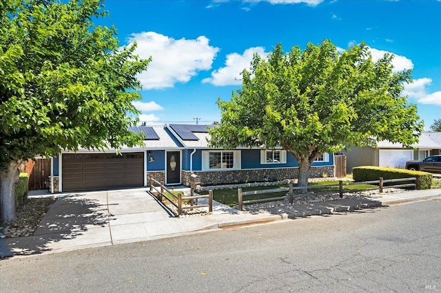 216 Walnut St, Suisun City, CA 94585 - view of front of home with stone siding, a garage, solar panels, and driveway
