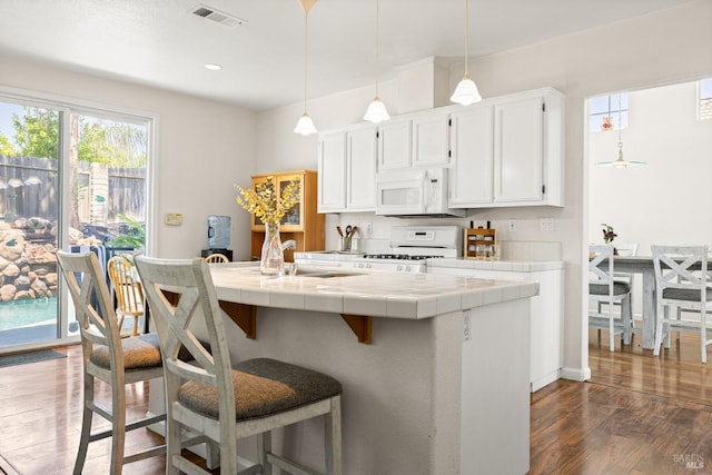2131 Hailstone Way, Antioch, CA 94509 - kitchen with white appliances, tile countertops, dark wood finished floors, white cabinets, and a breakfast bar
