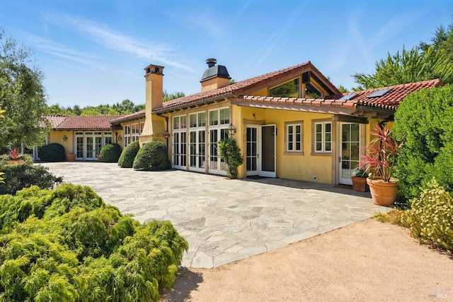 11018 Moonshine Rd, Sebastopol, CA 95472 - rear view of house with french doors, a chimney, a patio, stucco siding, and a tiled roof