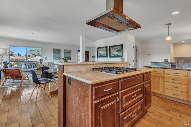 1130 W 9th St, Benicia, CA 94510 - kitchen with island range hood, stainless steel gas stovetop, open floor plan, light wood-style floors, and a center island