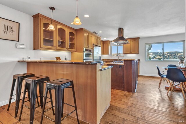 1130 W 9th St, Benicia, CA 94510 - kitchen with island range hood, glass insert cabinets, a peninsula, stainless steel refrigerator with ice dispenser, and a kitchen breakfast bar