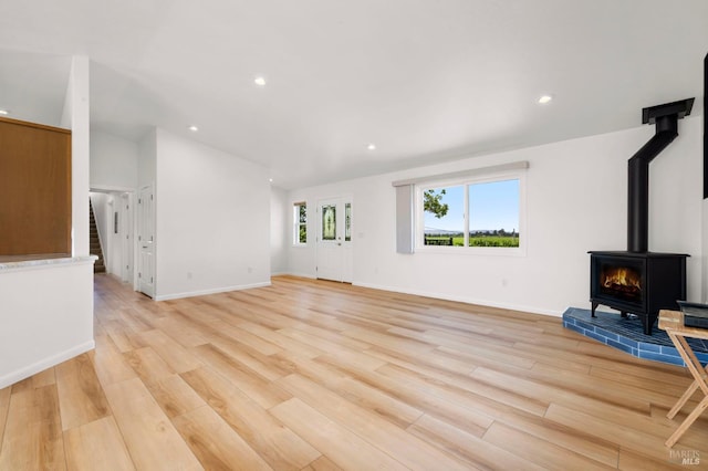 2290 Woolsey Rd, Fulton, CA 95439 - unfurnished living room featuring a wood stove, light wood finished floors, recessed lighting, lofted ceiling, and stairs