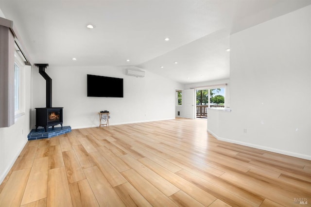 2290 Woolsey Rd, Fulton, CA 95439 - unfurnished living room featuring a wall unit AC, vaulted ceiling, light wood-type flooring, a wood stove, and recessed lighting