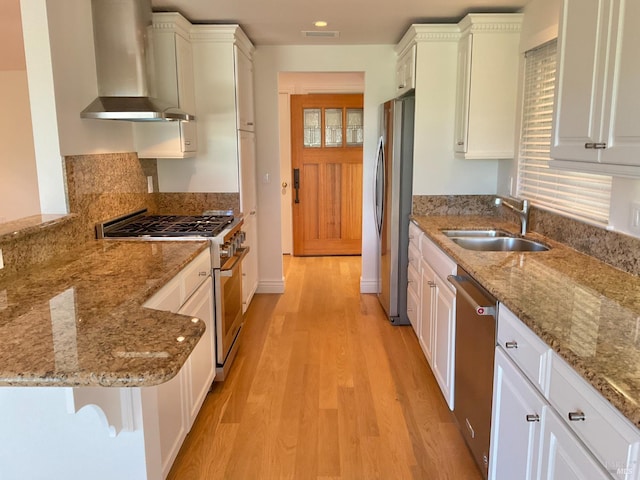 164 Oak Island Dr, Santa Rosa, CA 95409 - kitchen featuring appliances with stainless steel finishes, wall chimney range hood, white cabinetry, light wood finished floors, and recessed lighting