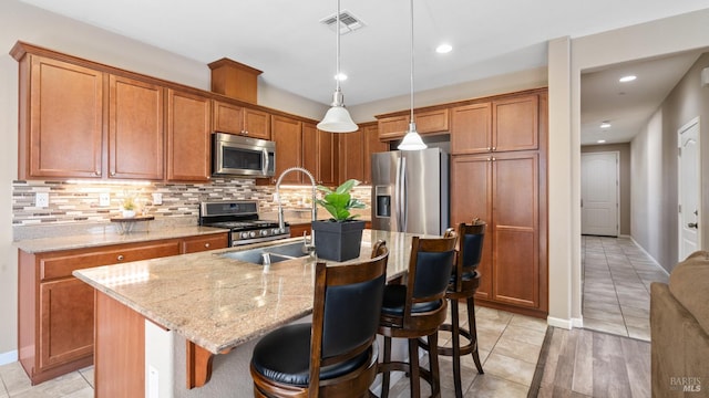524 Chaparral Loop, Vacaville, CA 95688 - kitchen featuring appliances with stainless steel finishes, tasteful backsplash, a breakfast bar, brown cabinetry, and recessed lighting