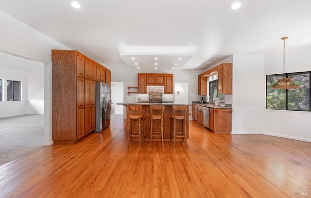 3604 Holly Ridge Dr, Santa Rosa, CA 95409 - kitchen featuring appliances with stainless steel finishes, brown cabinetry, a kitchen bar, light wood-style floors, and recessed lighting