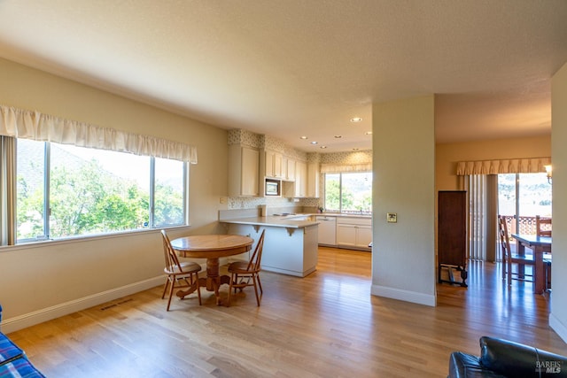 6327 Meadowridge Dr, Santa Rosa, CA 95409 - kitchen featuring stainless steel microwave, a peninsula, light wood-style floors, light countertops, and recessed lighting