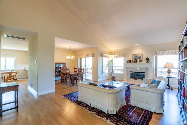 6327 Meadowridge Dr, Santa Rosa, CA 95409 - living room with a chandelier, plenty of natural light, light wood-type flooring, a tiled fireplace, and high vaulted ceiling