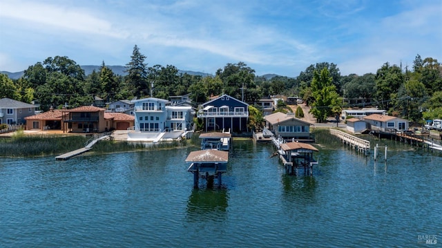 dock area with boat lift, a residential view, and a water view