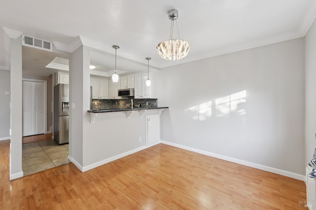 1255 Oak Ridge Ln, Pinole, CA 94564 - kitchen with appliances with stainless steel finishes, light wood-type flooring, a breakfast bar area, backsplash, and crown molding